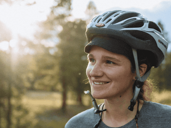 Megan McLellan wearing a bike helmet enjoying the garden view.