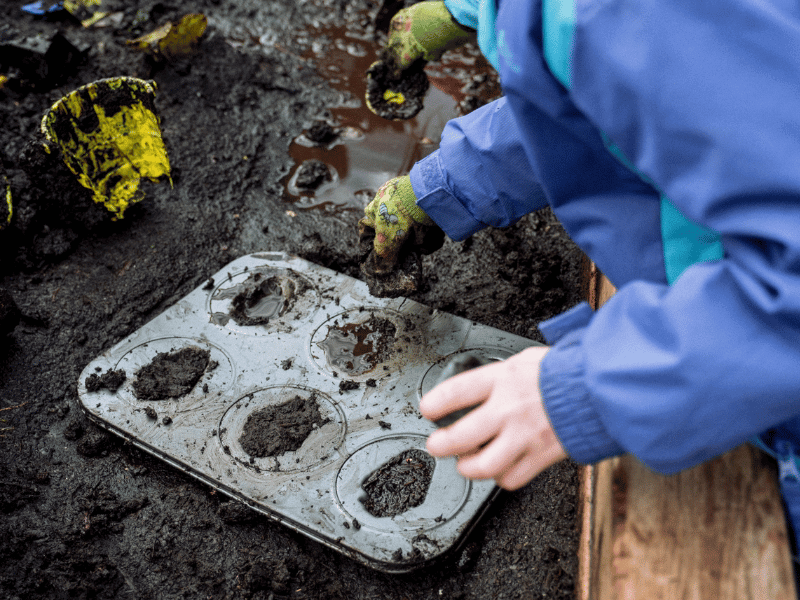 Child Making Mudpies In A Classroom Garden